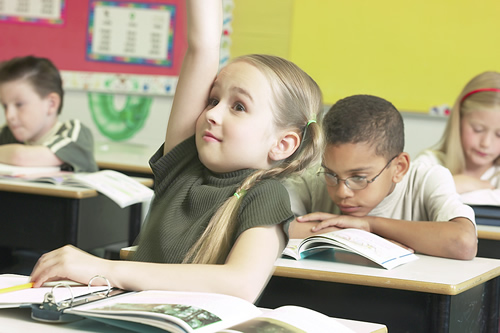 Female primary student raising hand.