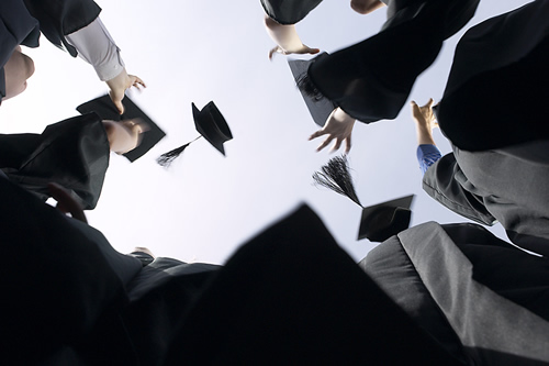 Students throwing graduation caps into the air. 