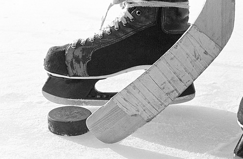 Photo of a hockey stick, puck and skate Photo of a hockey stick, puck and skate