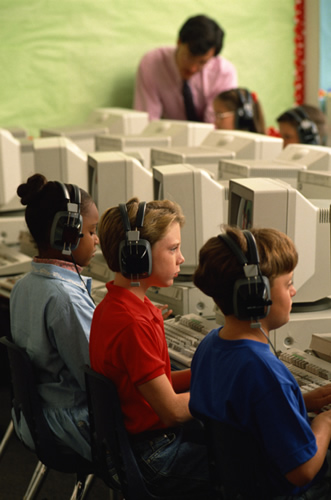 children on computers at school wearing headphones